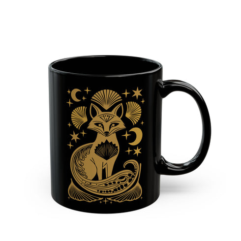 A black ceramic mug featuring a stylized golden fox design surrounded by Art Deco ginkgo fans, crescent moons, and stars. The mug has a glossy finish and ergonomic handle.